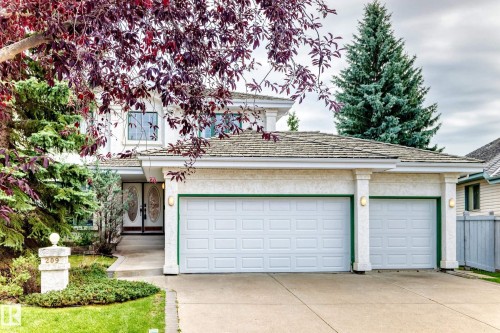Stucco exterior with a pitched shingle roof, double garage doors, and ornate front entry doors - 209 Carmichael Close Nw, Edmonton, AB - Outdoor