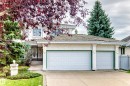 Stucco exterior with a pitched shingle roof, double garage doors, and ornate front entry doors - 209 Carmichael Close Nw, Edmonton, AB  - Outdoor 