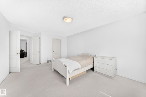 White paneled interior doors, white wall finishes, and light-toned carpeting - 209 Carmichael Close Nw, Edmonton, AB - Indoor Photo Showing Bedroom