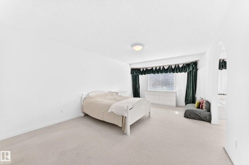 Light-toned carpeting, white walls, arched doorway, and built-in window - 209 Carmichael Close Nw, Edmonton, AB - Indoor Photo Showing Bedroom