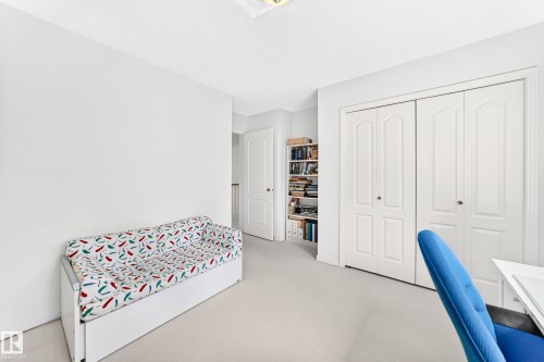 Carpeted room with white walls, ceiling-mounted light fixture, and built-in closet with bifold doors - 209 Carmichael Close Nw, Edmonton, AB - Indoor Photo Showing Bedroom