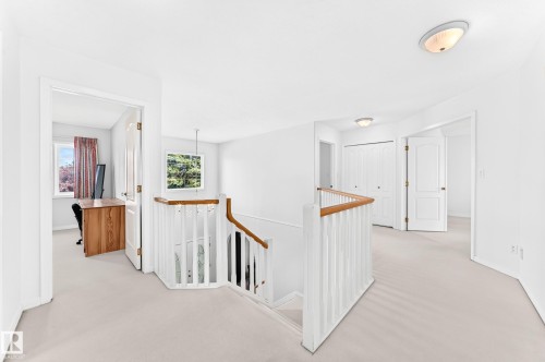 Carpeted upper level with white walls, white doors, and a wood-finish handrail - 209 Carmichael Close Nw, Edmonton, AB - Indoor Photo Showing Other Room