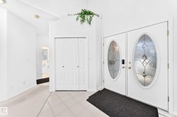 Double entry doors with decorative oval glass inserts, bi-fold closet doors, and tile flooring - 