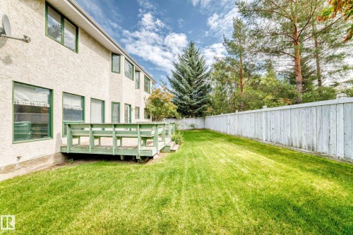 Expansive lawn area, private wood fence, wood deck, and stucco exterior - 209 Carmichael Close Nw, Edmonton, AB - Outdoor