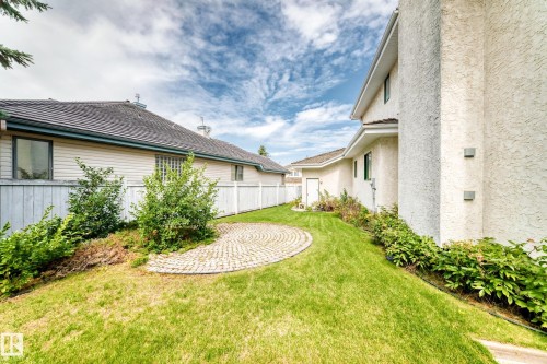 Expansive green space featuring a circular paver patio, established landscaping, and a privacy fence - 209 Carmichael Close Nw, Edmonton, AB - Outdoor
