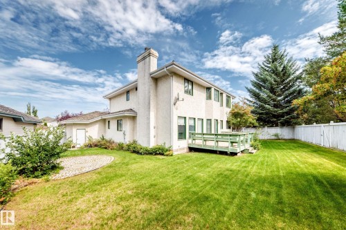 Expansive rear yard featuring a manicured lawn, mature trees, and a spacious outdoor deck - 209 Carmichael Close Nw, Edmonton, AB - Outdoor