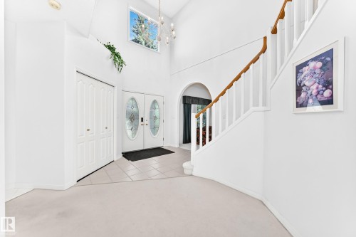 Foyer featuring a two-story ceiling, double-door entry with oval glass inserts, and a second-story window - 209 Carmichael Close Nw, Edmonton, AB - Indoor Photo Showing Other Room