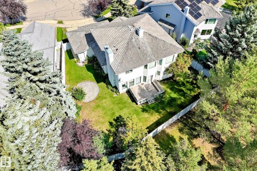 Expansive rear yard featuring a manicured lawn, established landscaping, and a ground-level deck - 209 Carmichael Close Nw, Edmonton, AB - Outdoor