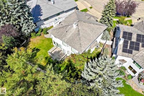 Pitched roofline residence with a rear deck, surrounded by mature trees and a manicured lawn - 209 Carmichael Close Nw, Edmonton, AB - Outdoor