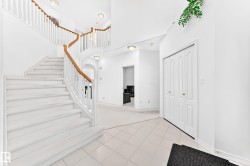 Curved staircase with wood-finish handrails, white balusters, and carpeted treads - 