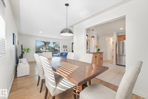 Open-concept dining area with wood-finish flooring, recessed lighting, and a modern pendant light fixture - 16613 90 Avenue Nw, Edmonton, AB - Indoor Photo Showing Dining Room