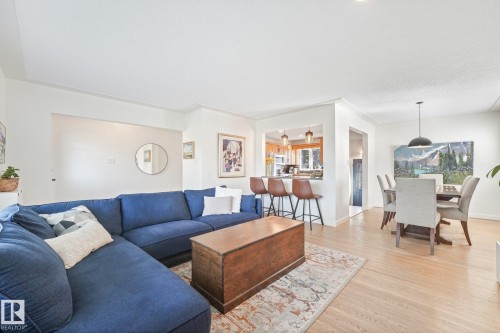 Light wood-finish flooring, recessed lighting, and a dining area with a modern pendant light - 16613 90 Avenue Nw, Edmonton, AB - Indoor Photo Showing Living Room