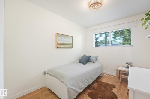 Recessed window with blinds, wood-finish flooring, and a flush-mount ceiling light - 16613 90 Avenue Nw, Edmonton, AB - Indoor Photo Showing Bedroom