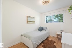 Recessed window with blinds, wood-finish flooring, and a flush-mount ceiling light - 