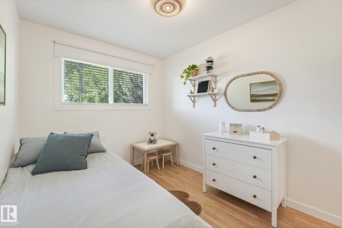 White walls, wood-finish flooring, and a large window with blinds - 16613 90 Avenue Nw, Edmonton, AB - Indoor Photo Showing Other Room