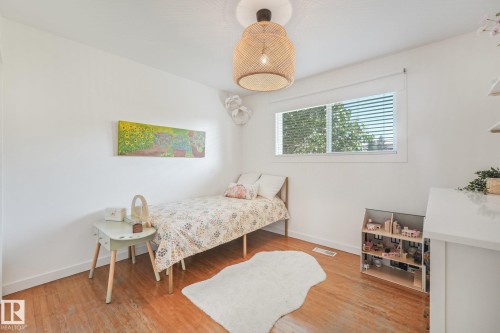 Wood-finish flooring with white walls and a woven ceiling light fixture - 16613 90 Avenue Nw, Edmonton, AB - Indoor Photo Showing Bedroom