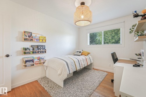 Hardwood flooring complemented by white walls, a single window with blinds, and a ceiling-mounted light fixture - 16613 90 Avenue Nw, Edmonton, AB - Indoor Photo Showing Bedroom