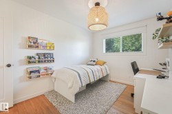 Hardwood flooring complemented by white walls, a single window with blinds, and a ceiling-mounted light fixture - 