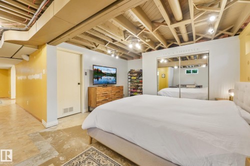Exposed ceiling joists with recessed lighting, full mirrored closet doors, and light-colored flooring - 16613 90 Avenue Nw, Edmonton, AB - Indoor Photo Showing Bedroom