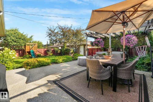 Expansive backyard featuring a concrete patio, a wooden pergola, and a grassy area with mature plantings - 16613 90 Avenue Nw, Edmonton, AB - Outdoor With Deck Patio Veranda