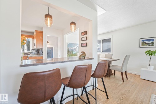 Kitchen pass-through with a stone-finish countertop and pendant lighting - 16613 90 Avenue Nw, Edmonton, AB - Indoor Photo Showing Dining Room