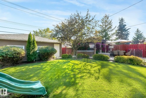 Expansive lawn with mature landscaping, a private patio, and a dedicated hot tub area - 16613 90 Avenue Nw, Edmonton, AB - Outdoor