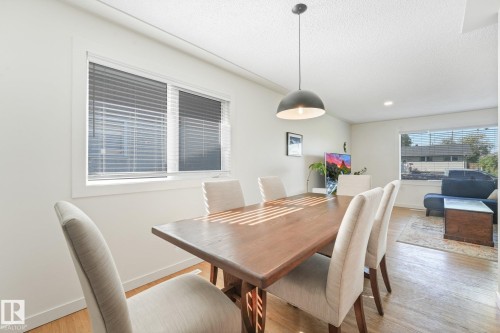 Recessed lighting, large window with blinds, wood-finish flooring, and a contemporary pendant light fixture - 16613 90 Avenue Nw, Edmonton, AB - Indoor Photo Showing Dining Room