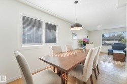 Recessed lighting, large window with blinds, wood-finish flooring, and a contemporary pendant light fixture - 