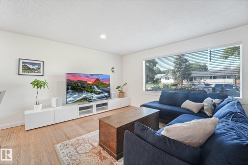 Recessed lighting, light wood-finish flooring, white walls, and a wide window with blinds - 16613 90 Avenue Nw, Edmonton, AB - Indoor Photo Showing Living Room