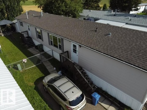 Exterior featuring a shingle roof, light-colored siding, and multiple windows - #56 4202 45 St, Wetaskiwin, AB - Outdoor