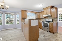 Kitchen featuring wood cabinetry, stainless steel range, tiled backsplash, and tile flooring - 