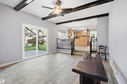Vaulted ceiling with exposed beams, wood-finish flooring, and sliding glass patio doors - 3432 Hill View Crescent Nw, Edmonton, AB - Indoor