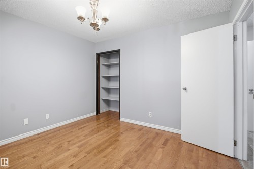 Light wood-finish flooring with a textured ceiling - 3432 Hill View Crescent Nw, Edmonton, AB - Indoor Photo Showing Other Room