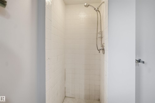 White tiled shower enclosure with a chrome shower head and fixture - 3432 Hill View Crescent Nw, Edmonton, AB - Indoor Photo Showing Bathroom