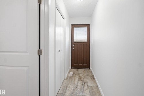 Wood-finish flooring, white walls, and a brown door with an upper window - 3432 Hill View Crescent Nw, Edmonton, AB - Indoor Photo Showing Other Room