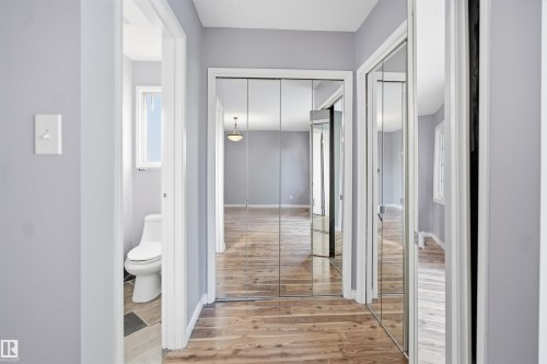Mirrored closet doors, wood-finish flooring, and light gray wall paint - 3432 Hill View Crescent Nw, Edmonton, AB - Indoor