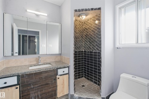 Vanity with a granite-style countertop, undermount sink, and chrome faucet - 3432 Hill View Crescent Nw, Edmonton, AB - Indoor Photo Showing Bathroom