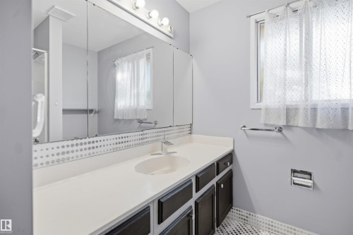 Extended vanity with integrated sink, black cabinetry, and a large wall-mounted mirror - 3432 Hill View Crescent Nw, Edmonton, AB - Indoor Photo Showing Bathroom