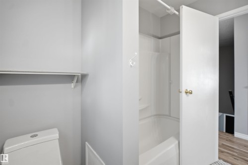White bathtub with a shower surround and wall-mounted hook - 3432 Hill View Crescent Nw, Edmonton, AB - Indoor