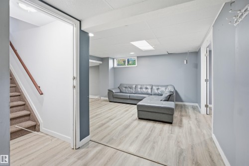 Finished lower level with light wood-finish flooring, recessed lighting, drop ceiling, and a single window - 3432 Hill View Crescent Nw, Edmonton, AB - Indoor Photo Showing Other Room