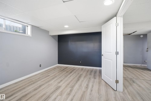 Wood-finish flooring with light gray walls, a contrasting dark accent wall, and recessed ceiling lighting - 3432 Hill View Crescent Nw, Edmonton, AB - Indoor