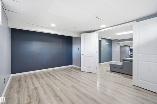 Recessed lighting, wood-finish flooring, two-panel interior doors, and a drop panel ceiling - 3432 Hill View Crescent Nw, Edmonton, AB - Indoor Photo Showing Other Room