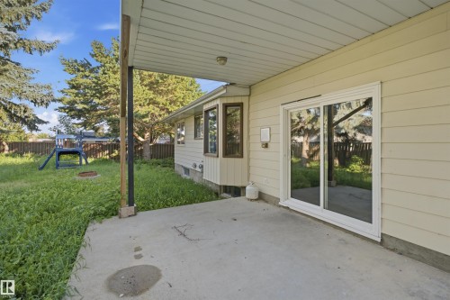Concrete patio with a covered section, siding exterior, and sliding glass door - 3432 Hill View Crescent Nw, Edmonton, AB - Outdoor With Exterior
