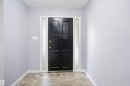 Front entry with a paneled door, textured glass sidelights, and tile flooring - 3432 Hill View Crescent Nw, Edmonton, AB  - Indoor Photo Showing Other Room 