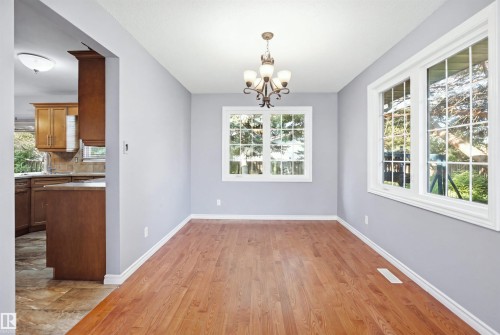 Hardwood-finish flooring with crisp white trim - 3432 Hill View Crescent Nw, Edmonton, AB - Indoor Photo Showing Other Room