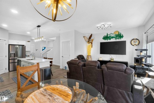 Open-concept interior featuring light wood-finish flooring, recessed lighting, and a modern ceiling fixture - 91 Hilton Cove, Spruce Grove, AB - Indoor