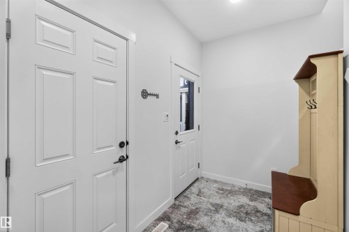 Entryway featuring white panel doors, overhead lighting, and a durable flooring surface - 91 Hilton Cove, Spruce Grove, AB - Indoor Photo Showing Other Room