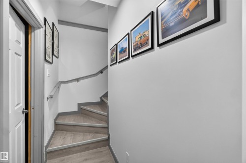 Staircase featuring wood-finish treads, light gray wall color, and a gray handrail - 91 Hilton Cove, Spruce Grove, AB - Indoor Photo Showing Other Room