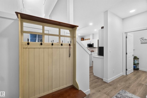 Wood-finish flooring throughout, bright white walls, recessed ceiling lighting, and a white interior door - 91 Hilton Cove, Spruce Grove, AB - Indoor Photo Showing Other Room