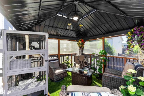 Covered outdoor structure with a slatted black roof, perimeter screening, and a wooden railing - 91 Hilton Cove, Spruce Grove, AB - Outdoor With Deck Patio Veranda With Exterior